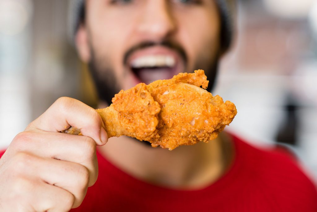 Owner Farid Biting Into Chicken